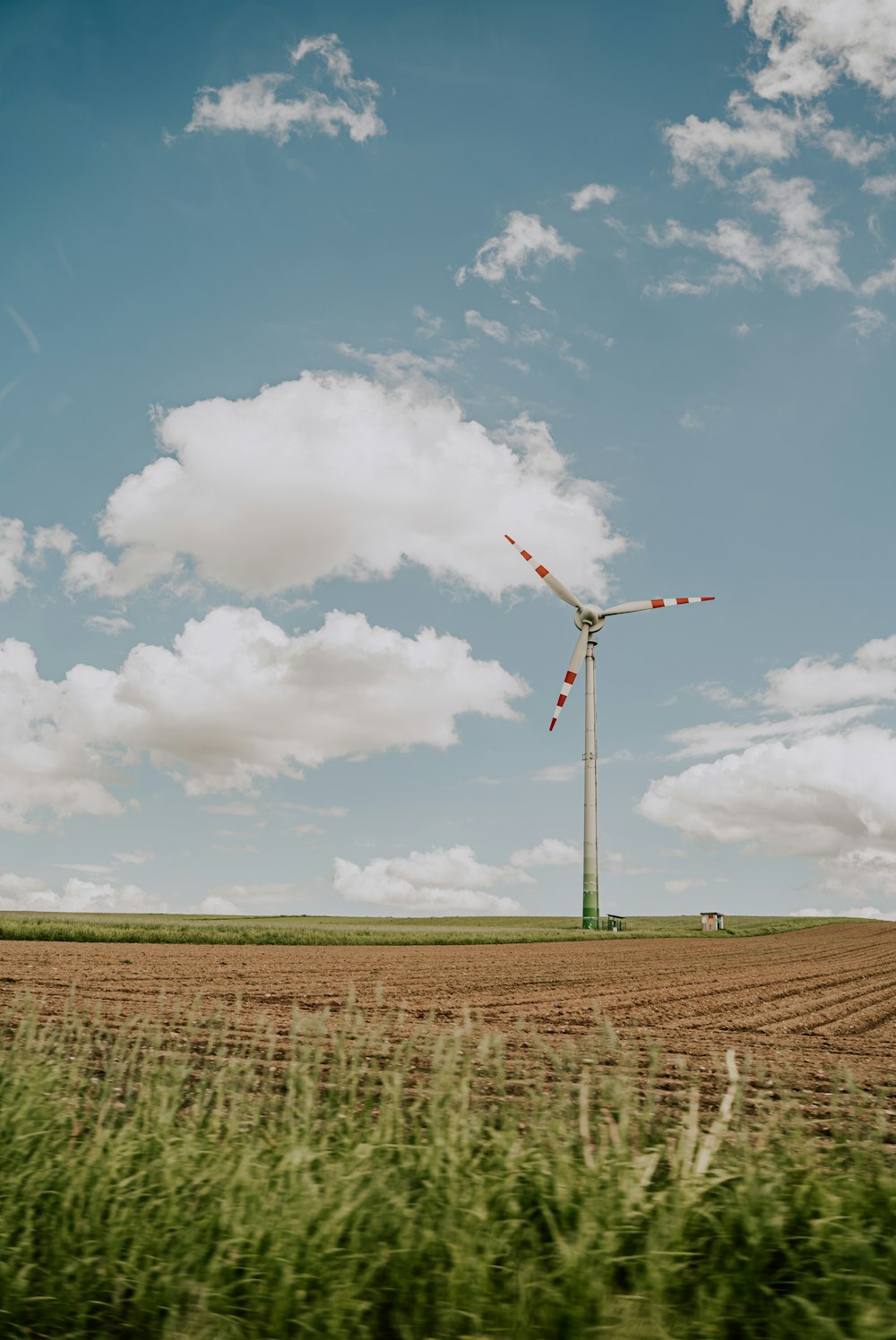 a wind turbine in a field with a sky background