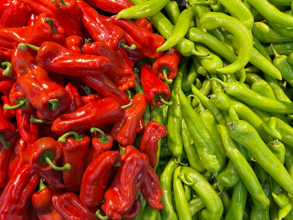 a pile of green and red peppers next to each other