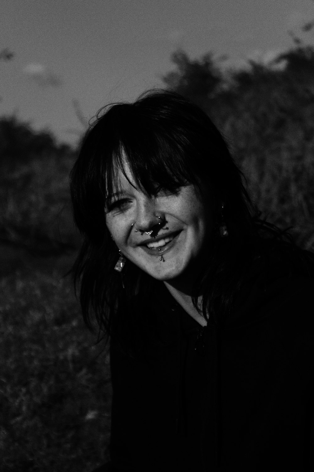 a black and white photo of a woman smiling