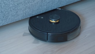 a black robot vacuum on a wooden floor