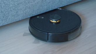a black robot vacuum on a wooden floor