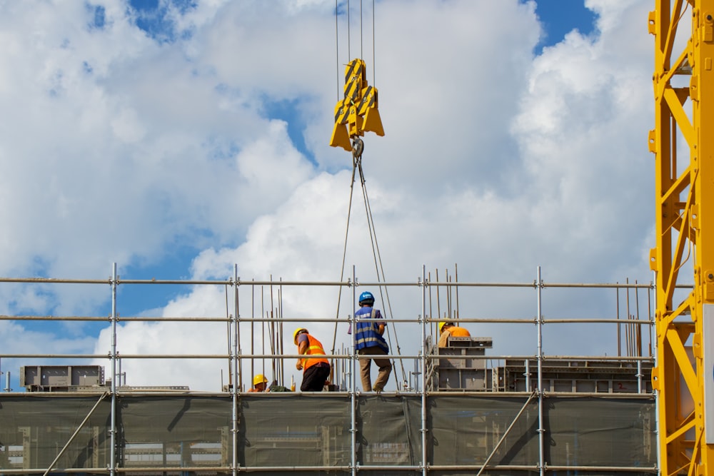 um grupo de homens em pé no topo de um edifício em construção