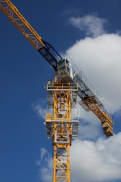 a yellow crane with a blue sky in the background