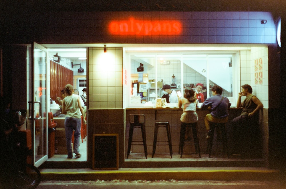 a group of people standing outside of a restaurant