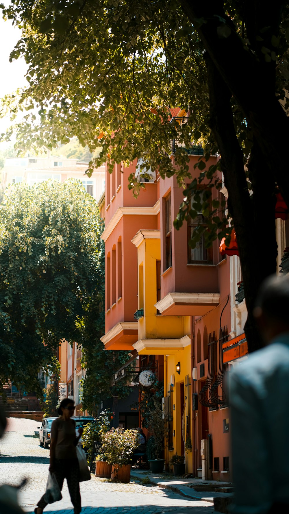 a person walking down a street in front of a building