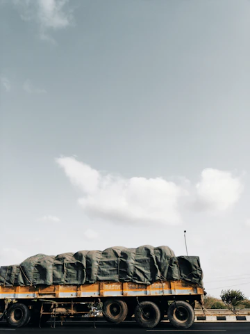 Close-up of a truck securely carrying multiple vehicles on a bright, clear day.