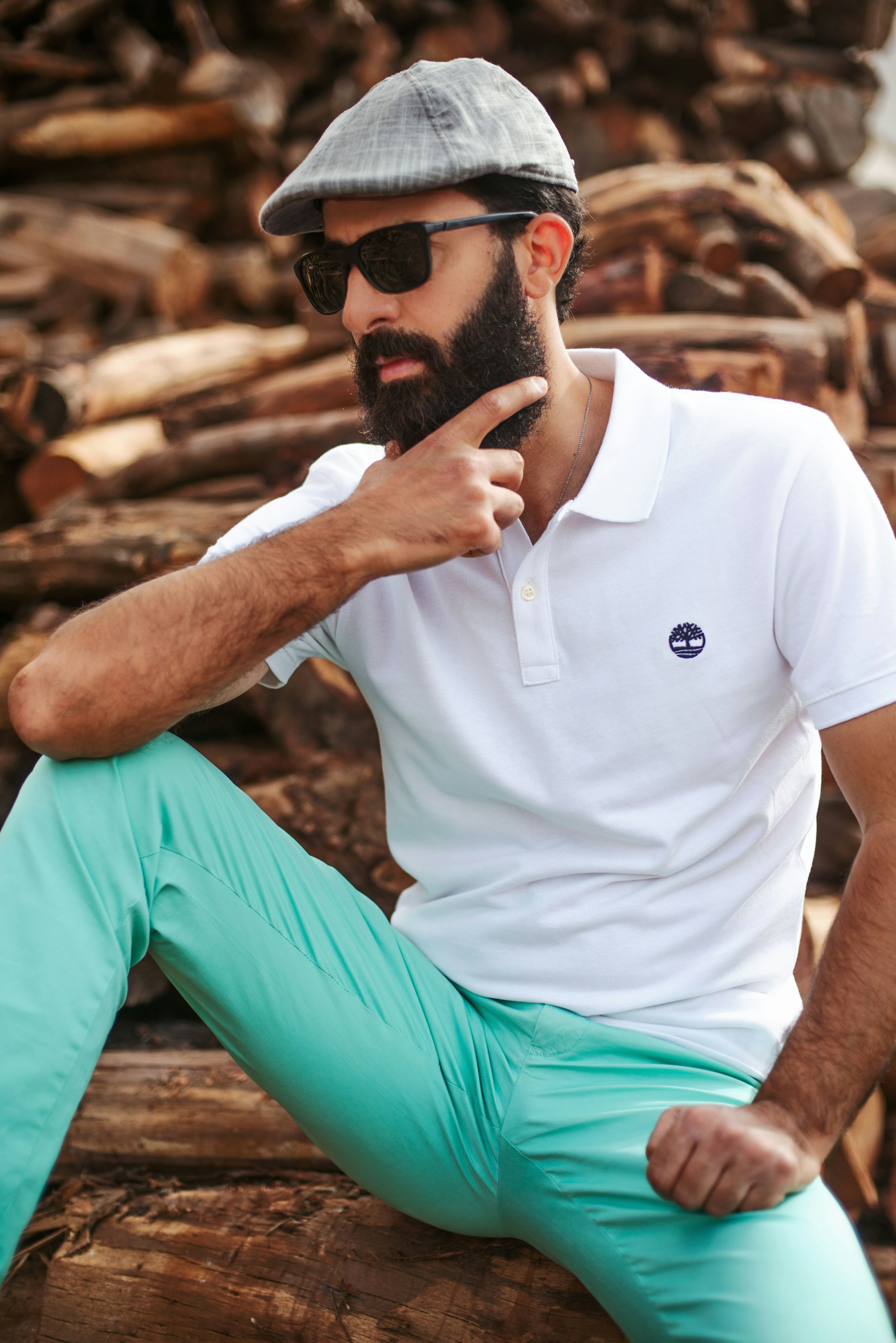 a man sitting on top of a pile of logs