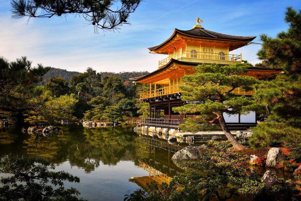 a pagoda in the middle of a lake surrounded by trees