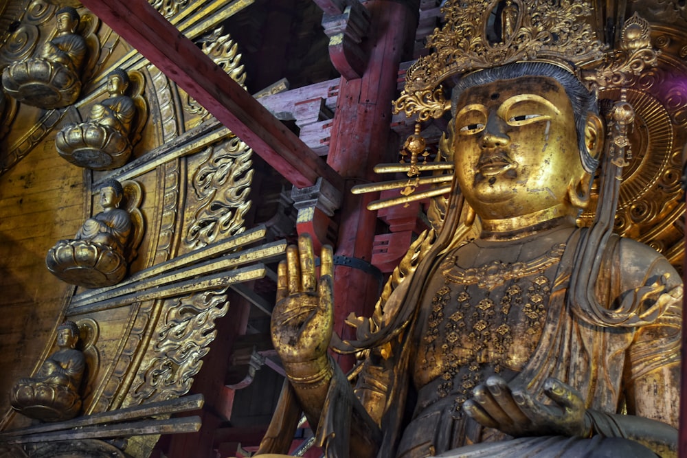 a golden statue of a person holding a cross