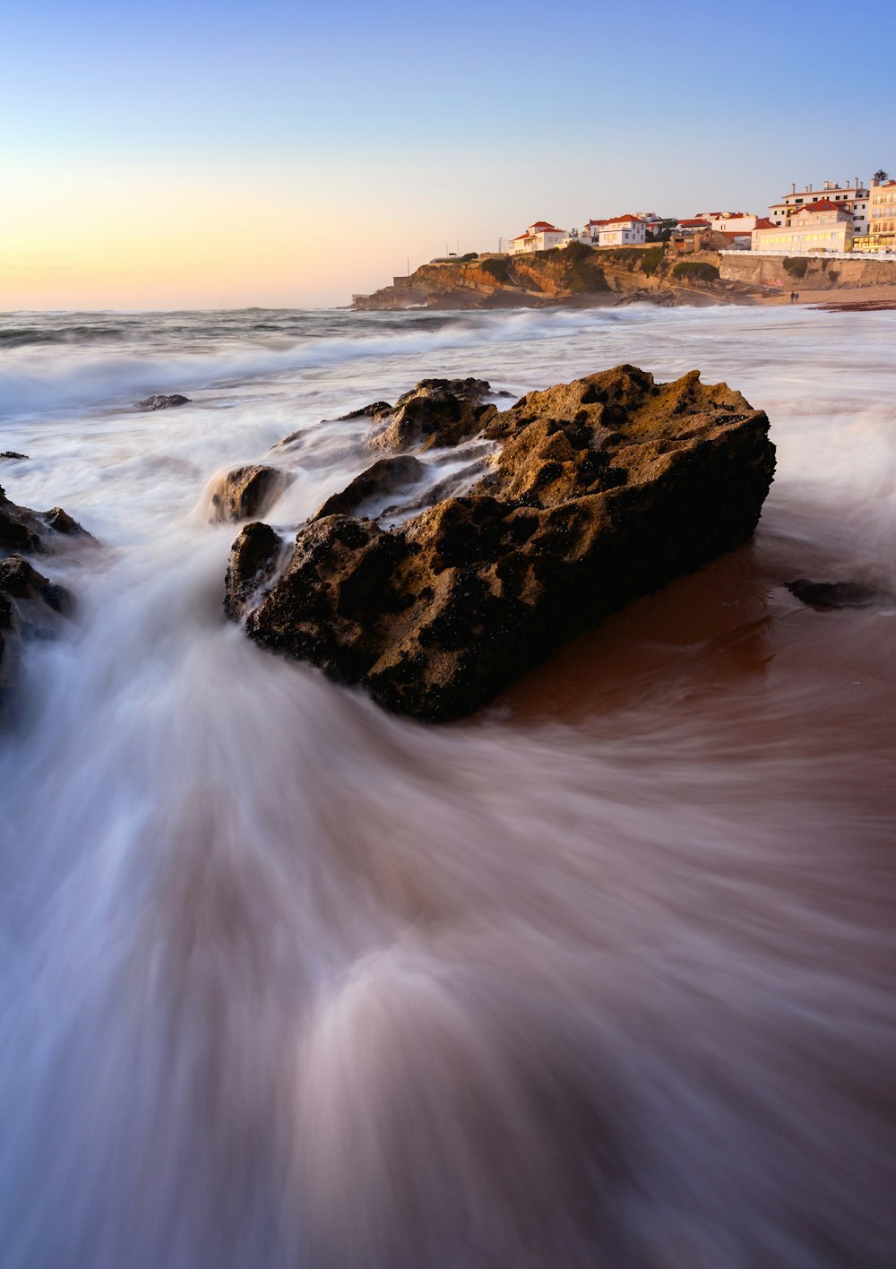 a long exposure photo of the ocean and rocks