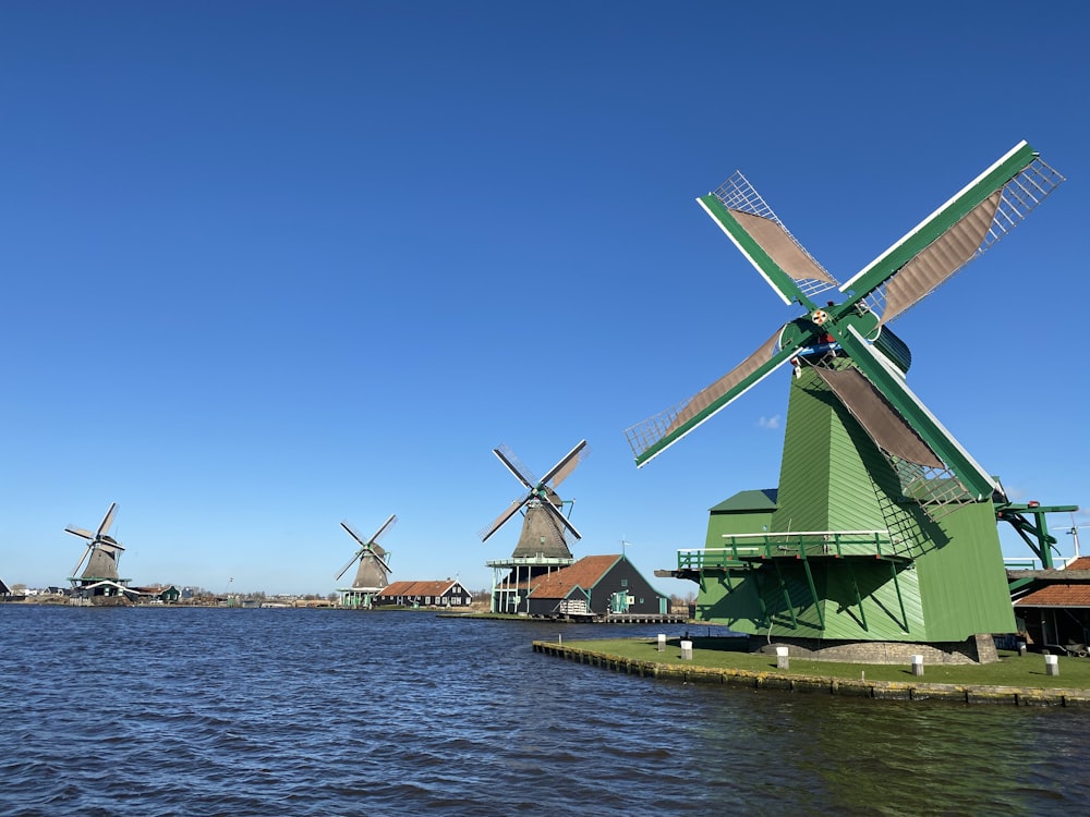 a row of windmills sitting next to a body of water