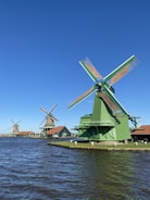 a row of windmills sitting next to a body of water