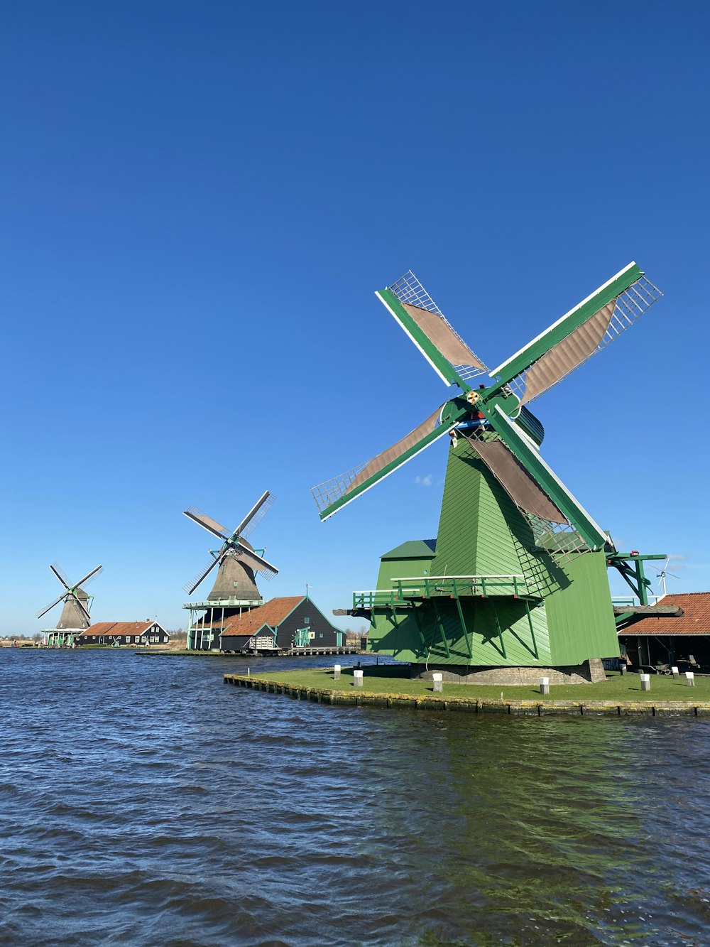 a row of windmills sitting next to a body of water