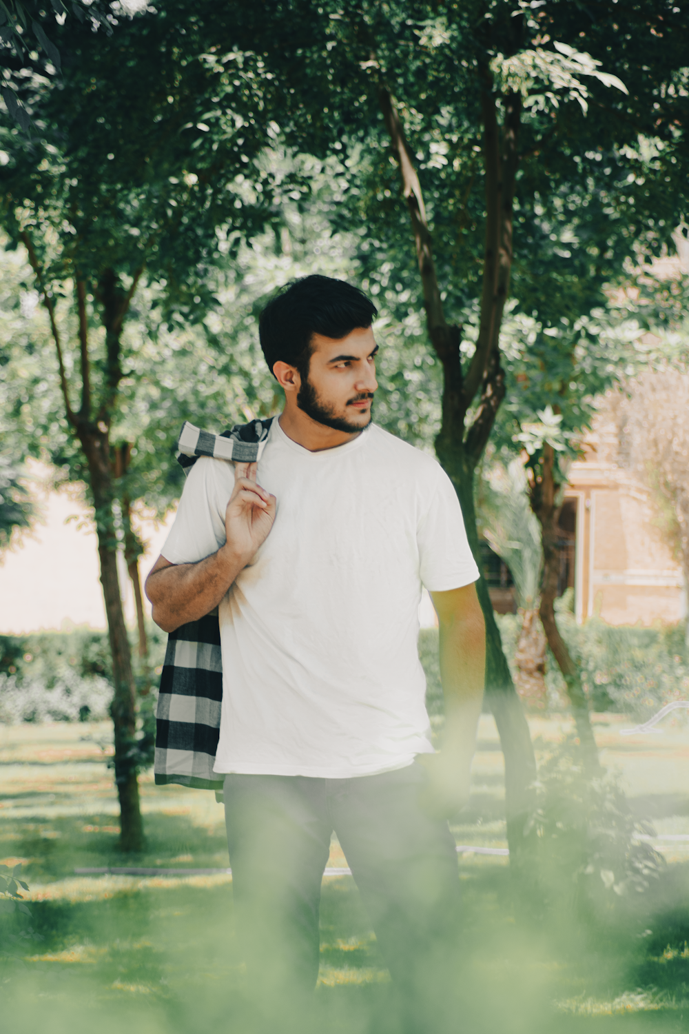 a man in a white shirt is standing in the grass