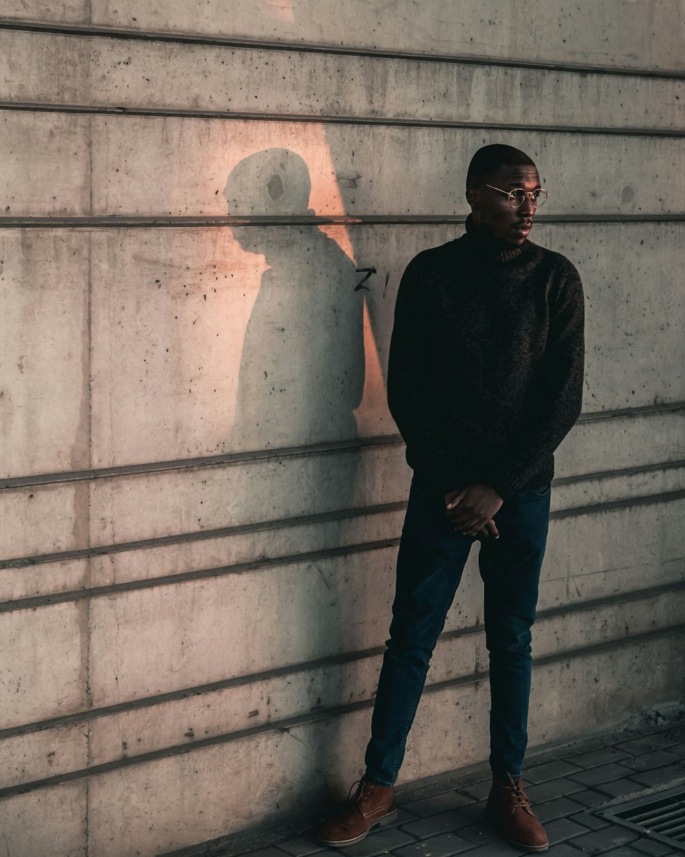 a man standing in front of a concrete wall