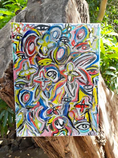 a painting is hanging on a tree trunk