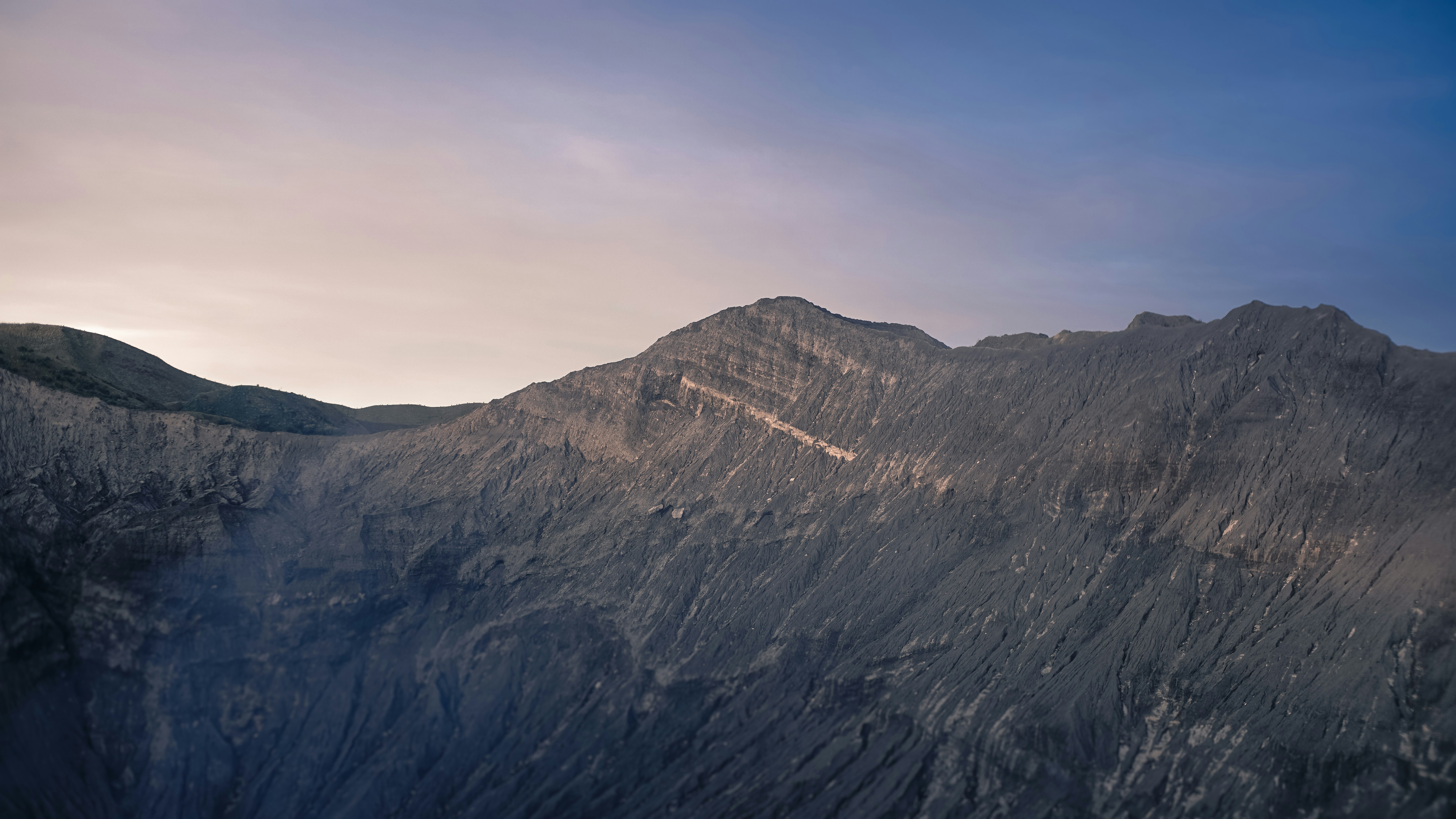 a very tall mountain with a sky in the background, salah satu sisi dinding kawah gunung bromo