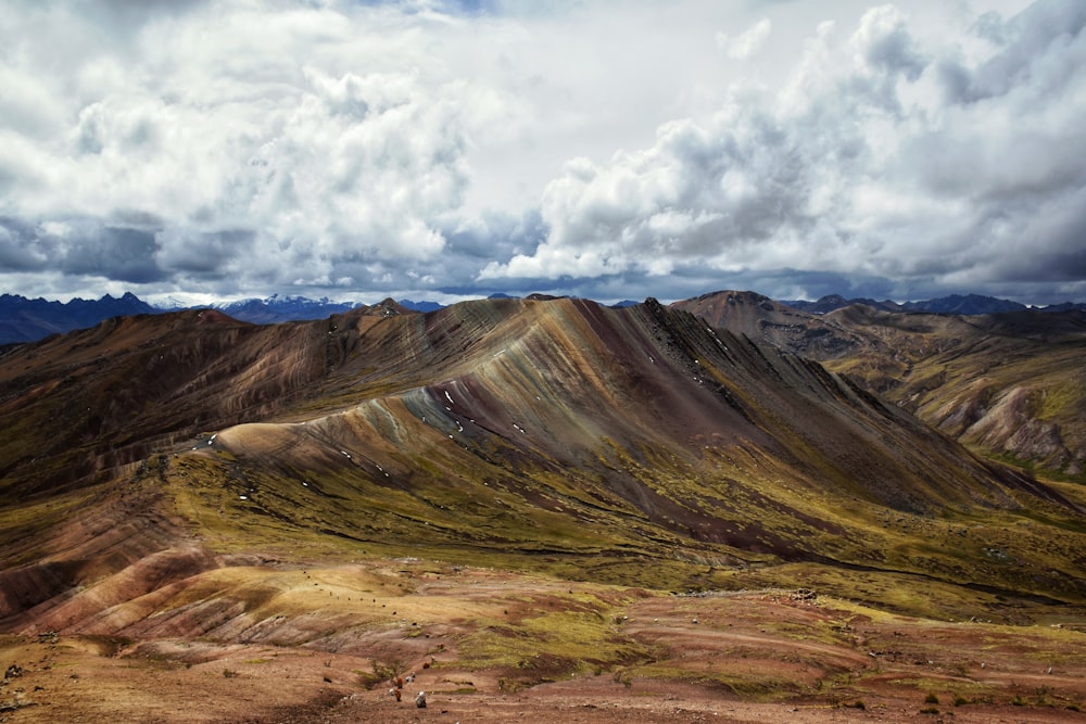 a view of a mountain range from the top of a hill