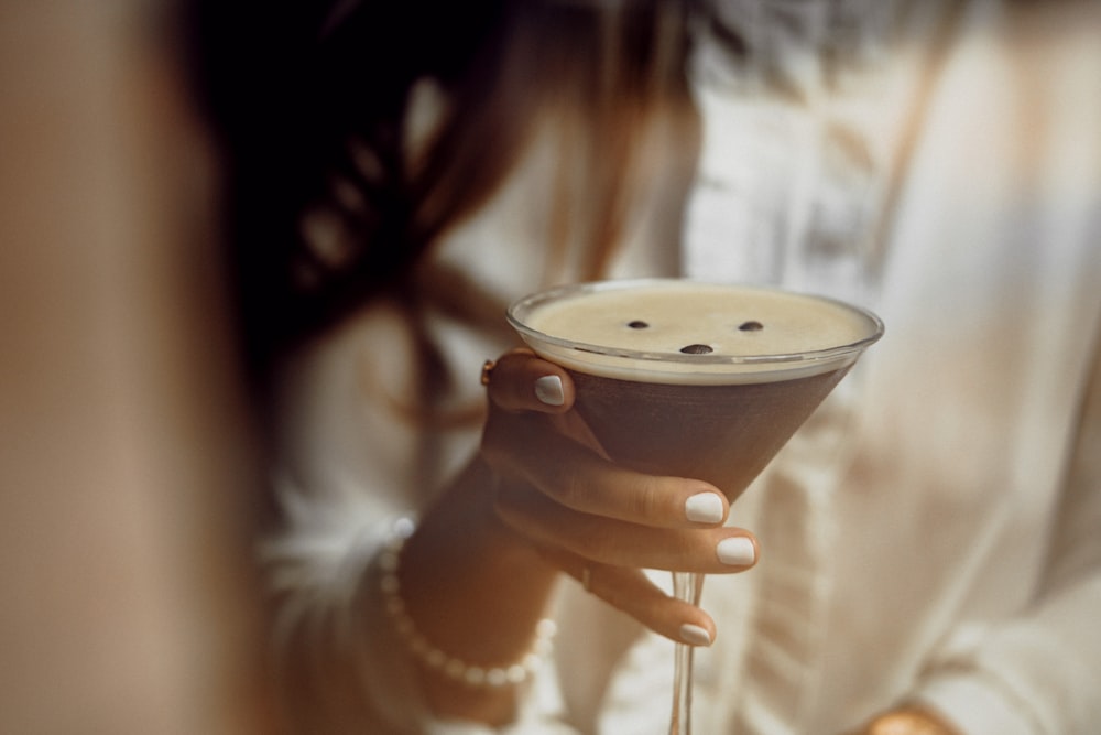 a close up of a person holding a drink