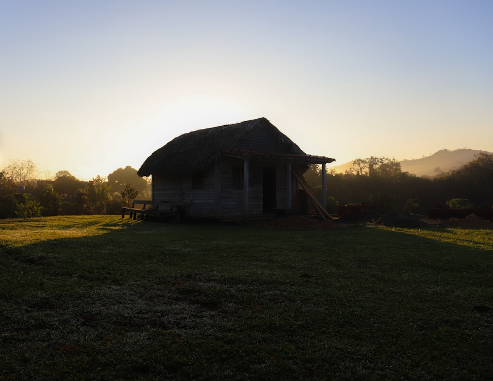 a small hut sitting on top of a lush green field