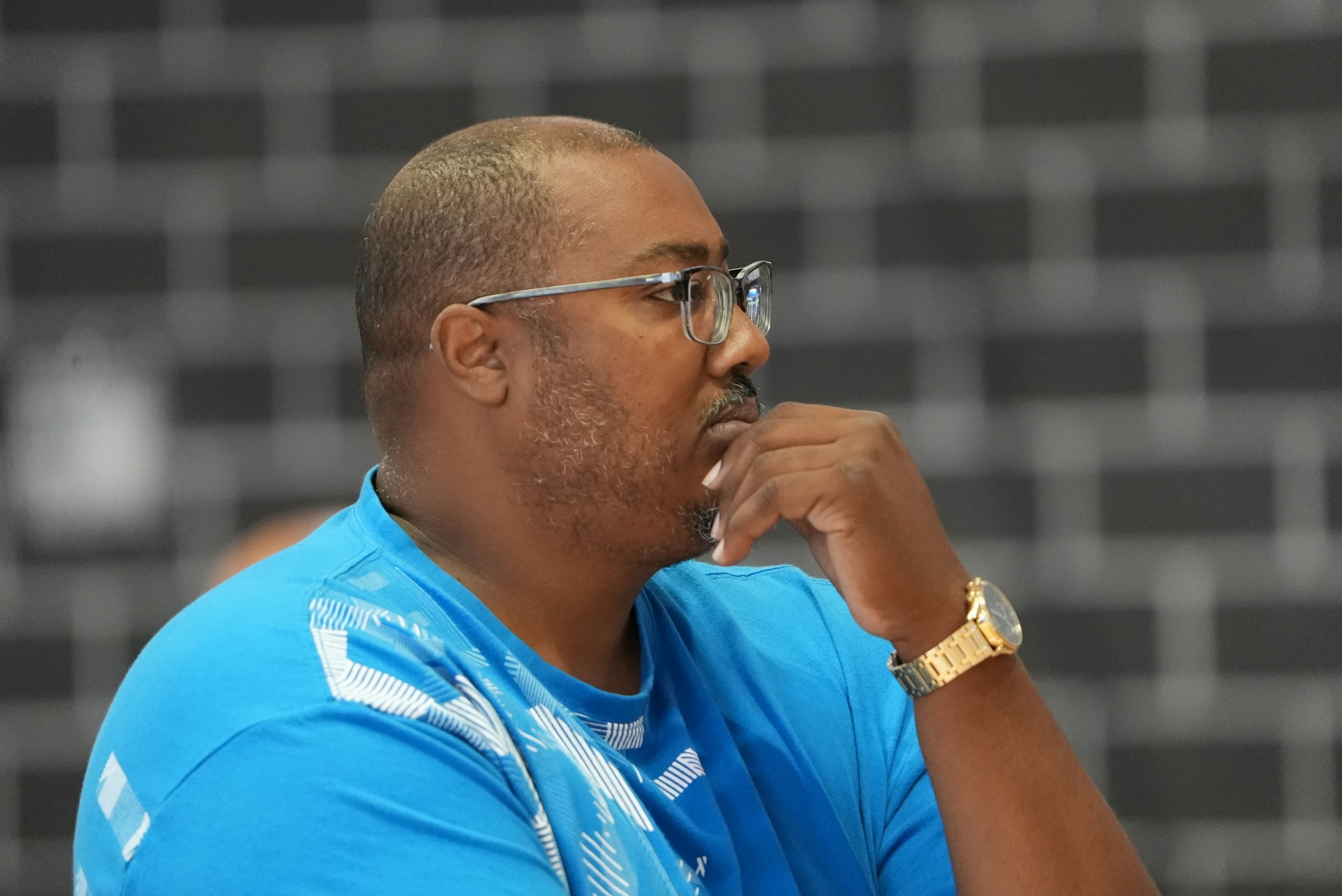 a man in a blue shirt with a watch on his left hand