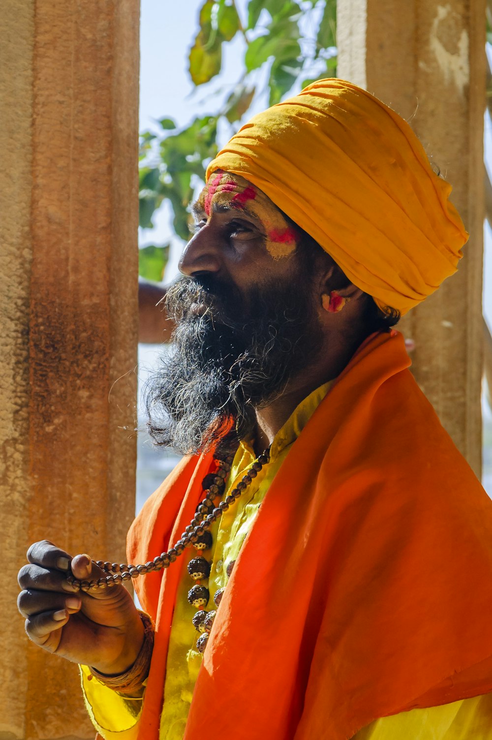 a man with a beard wearing an orange turban