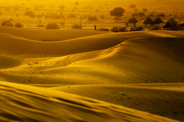 Golden dunes glowing under a vibrant sunset in the Moroccan desert.