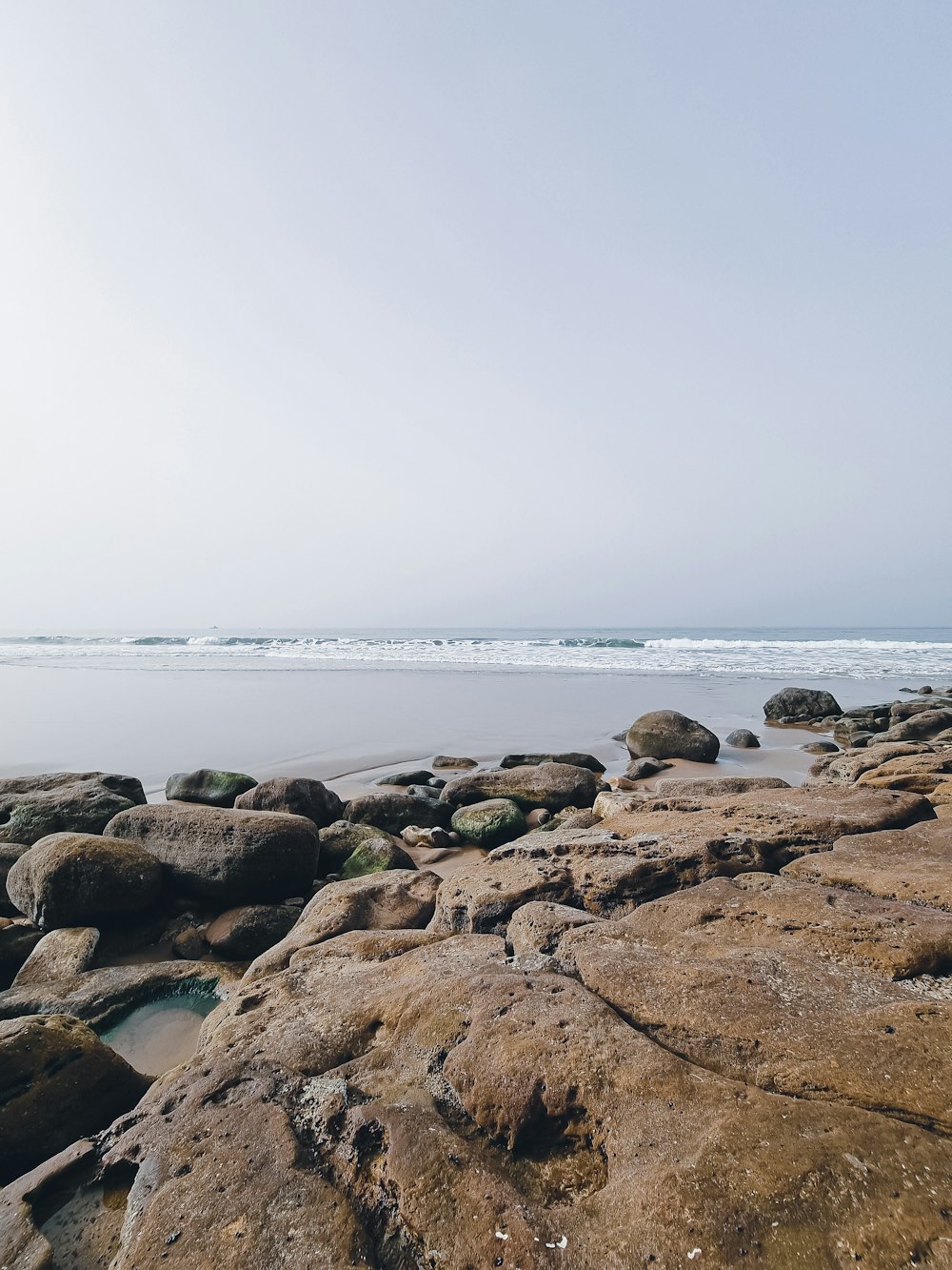 uma praia com rochas e um corpo de água