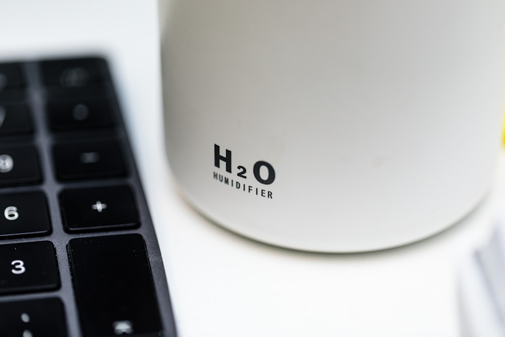 a close up of a keyboard and a cup