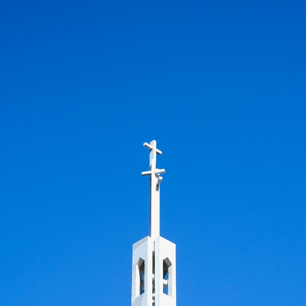 a white church steeple with a cross on top