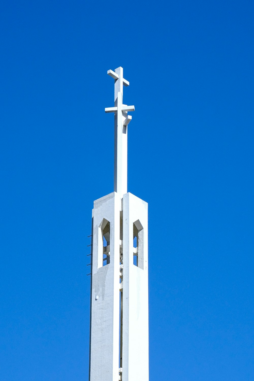 a tall white church steeple with a cross on top