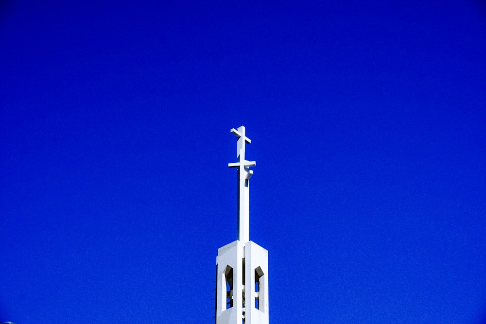 a white church steeple with a cross on top