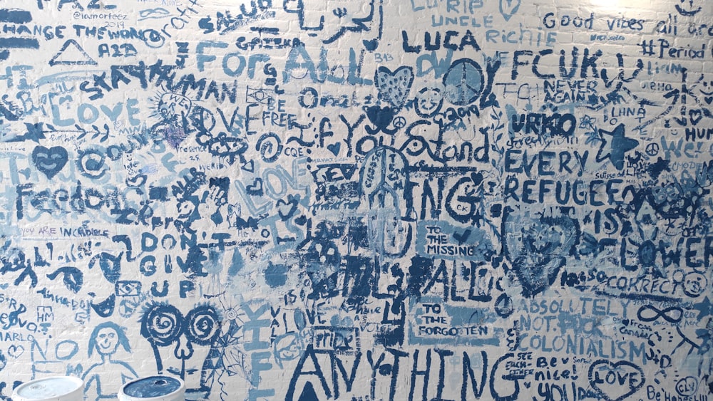 a blue and white wall with writing all over it