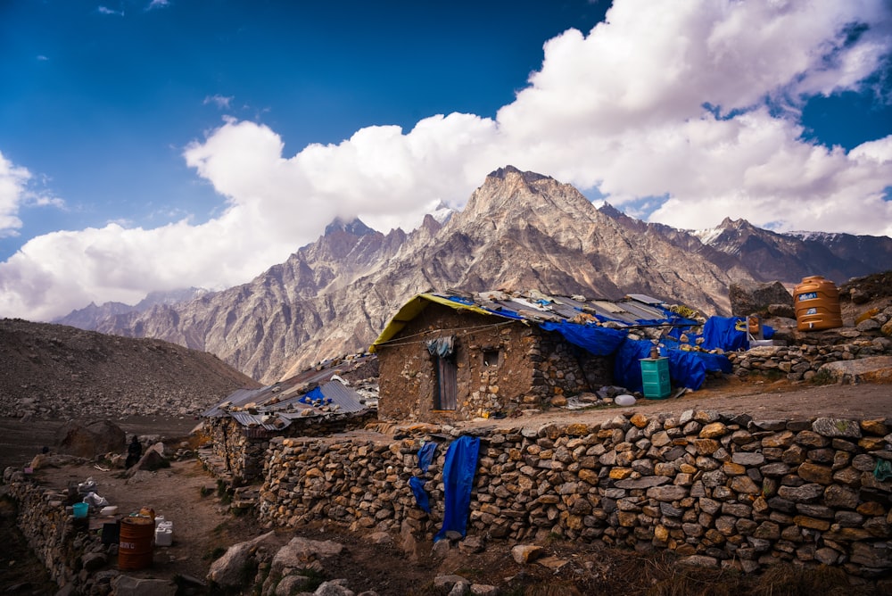 a stone house with a mountain in the background