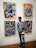 a man standing in front of two paintings