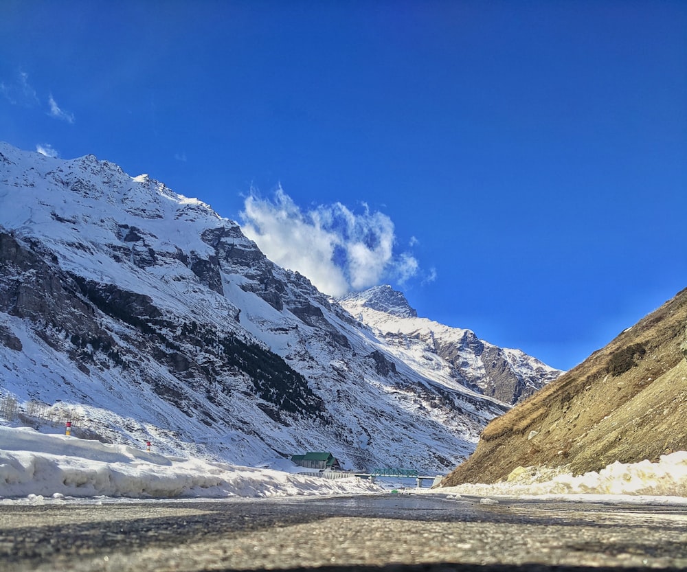 a snowy mountain with a road going through it