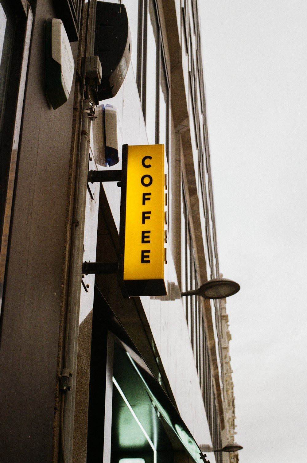 a yellow sign hanging from the side of a building
