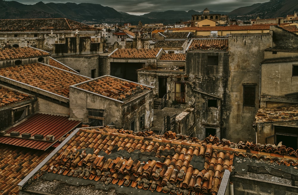 a view of a city with rooftops and mountains in the background