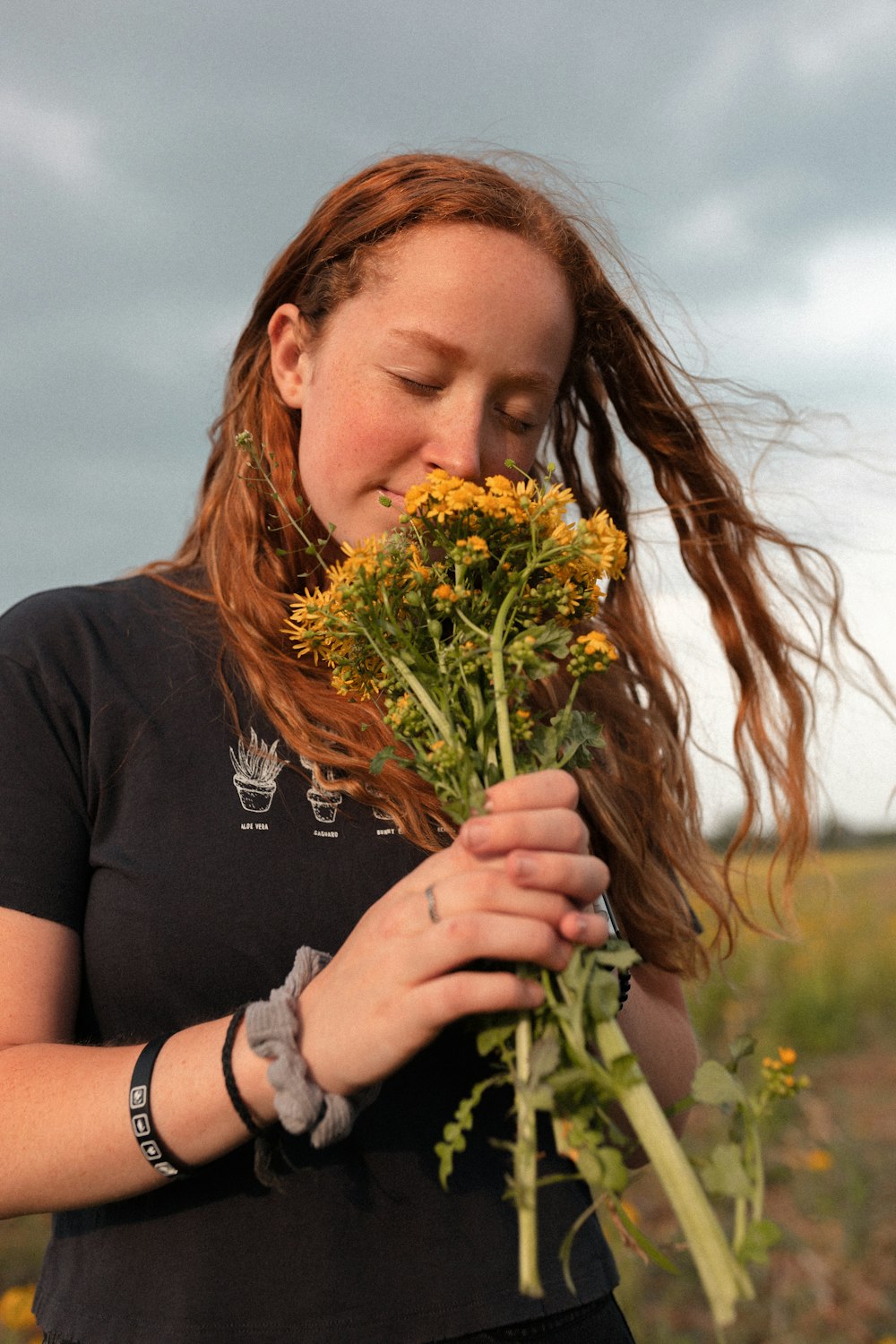 a woman holding a bunch of flowers in her hands