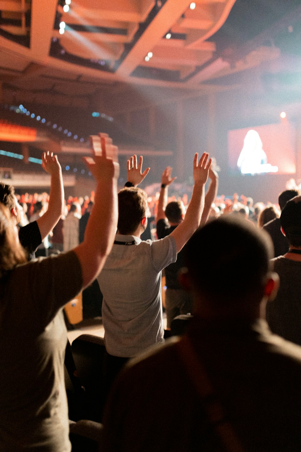 a group of people standing in a room with their hands up