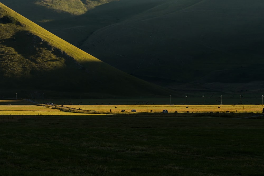 a grassy field with mountains in the background