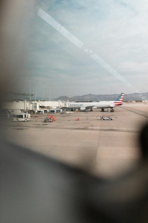 A jet parked at an airport gate with the jet bridge attached, similar to the gate setup planned for the new pier-style concourse