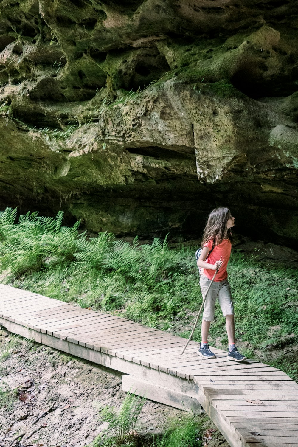 a little girl standing on a wooden walkway