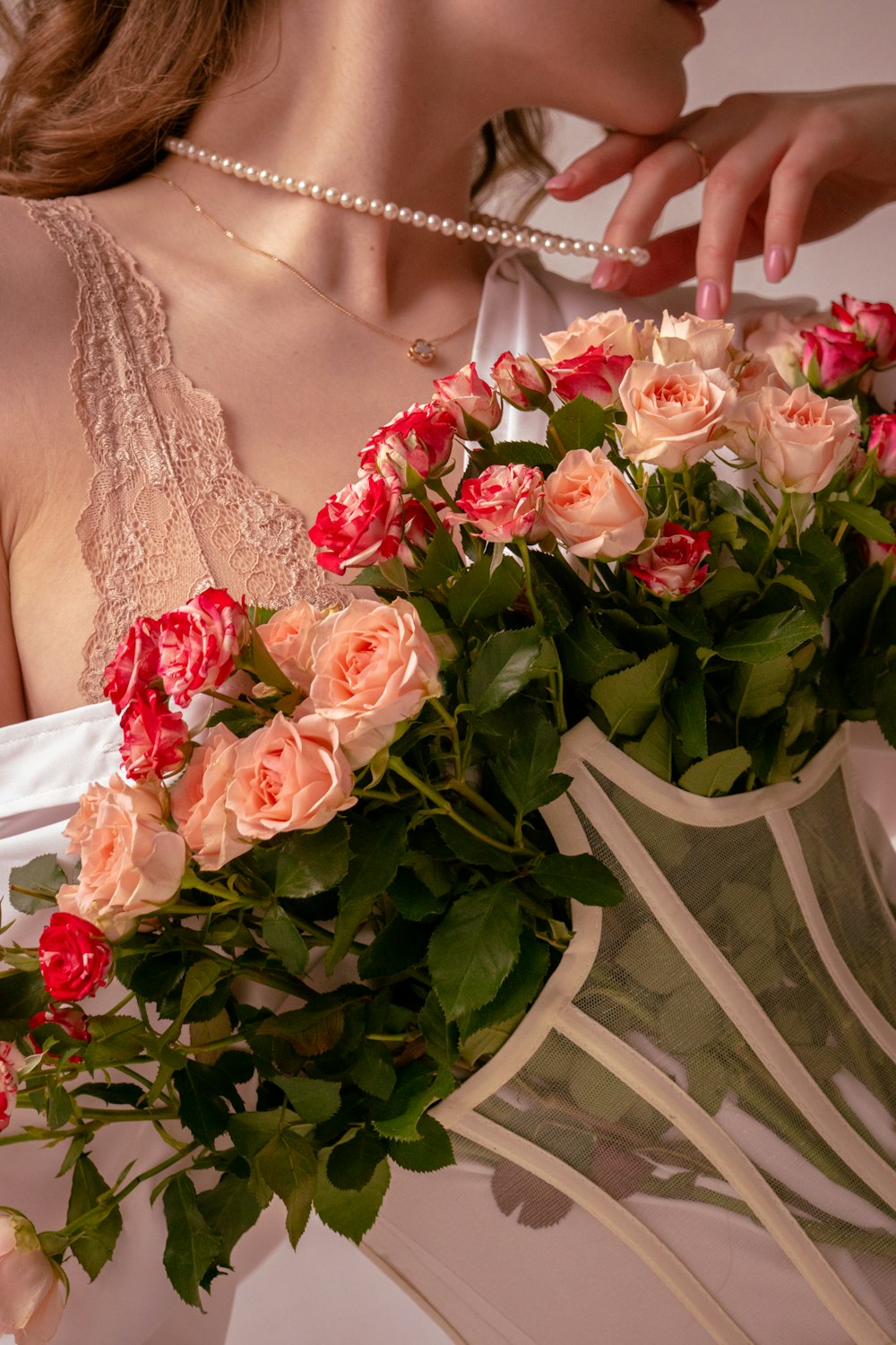 a woman in a white dress holding a bouquet of roses