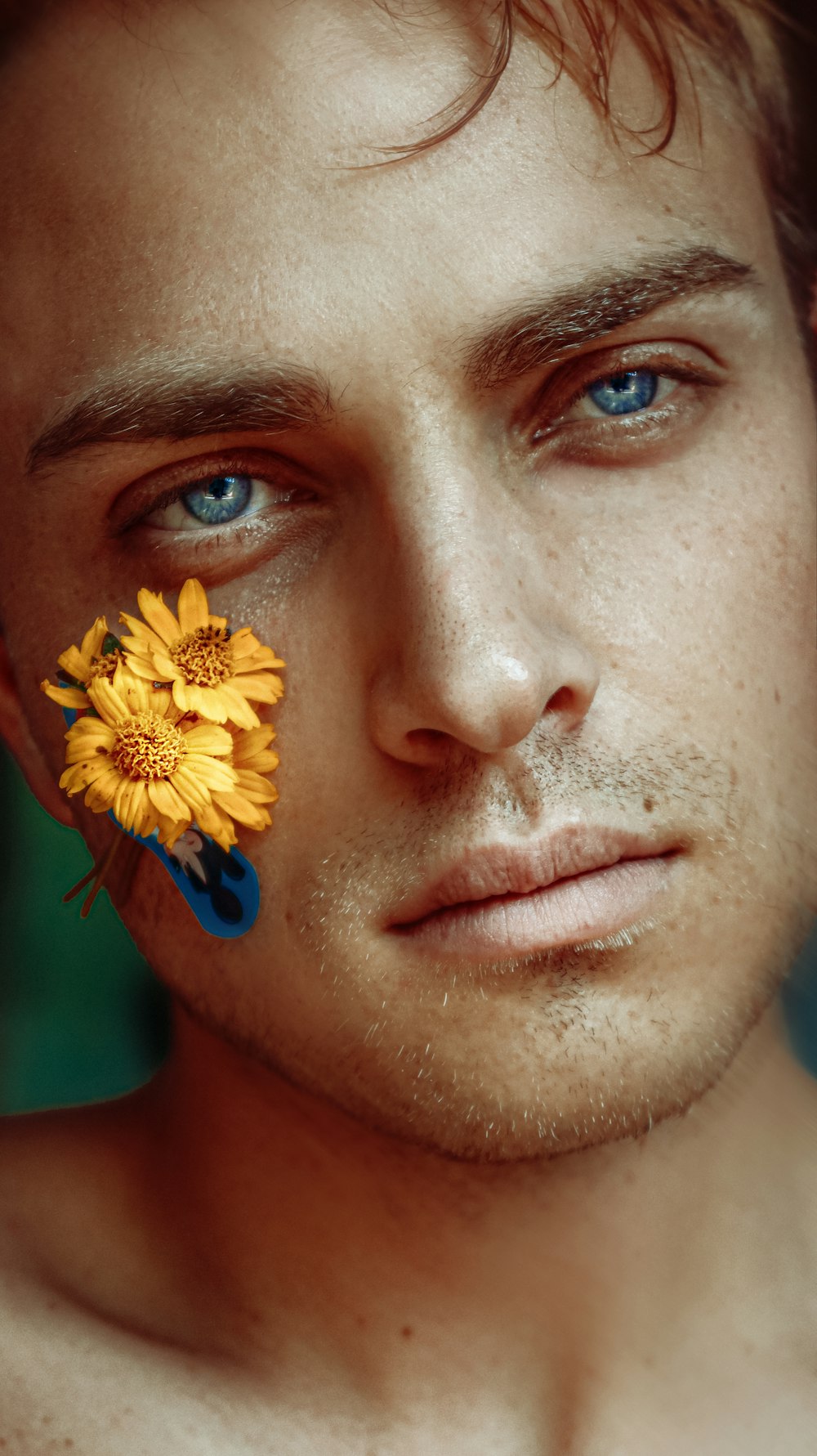 a man with a yellow flower on his forehead