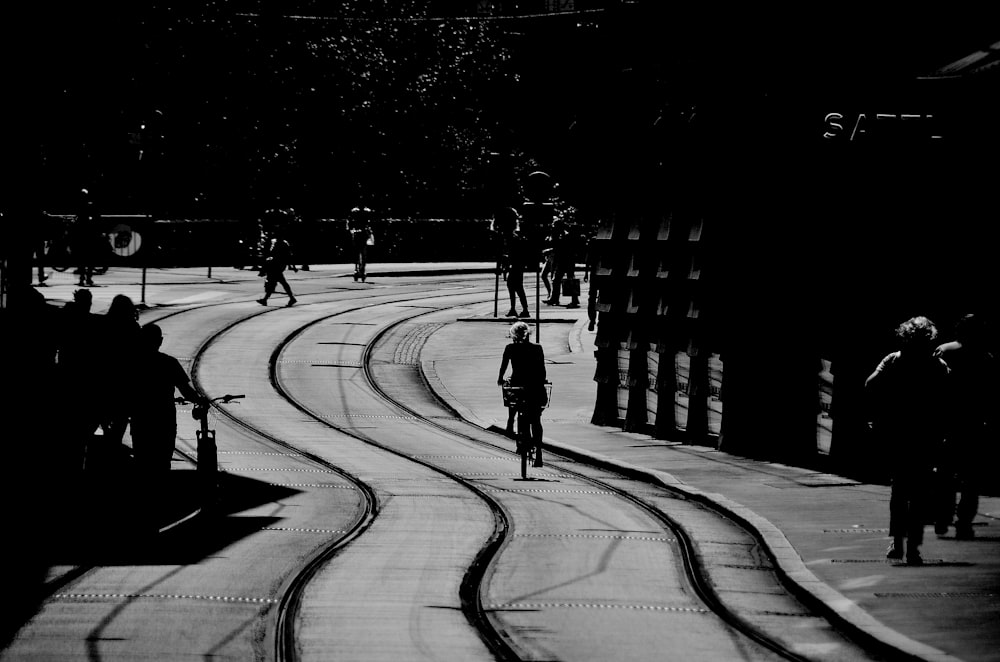 a black and white photo of a person riding a bike