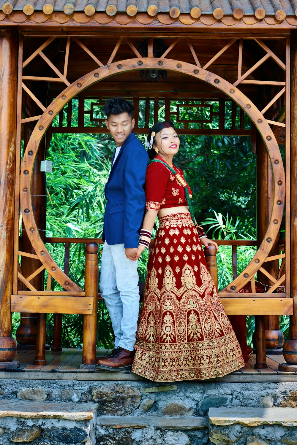a man and woman standing in front of a wooden structure