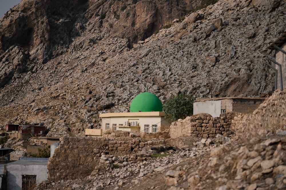a green dome on top of a building near a mountain