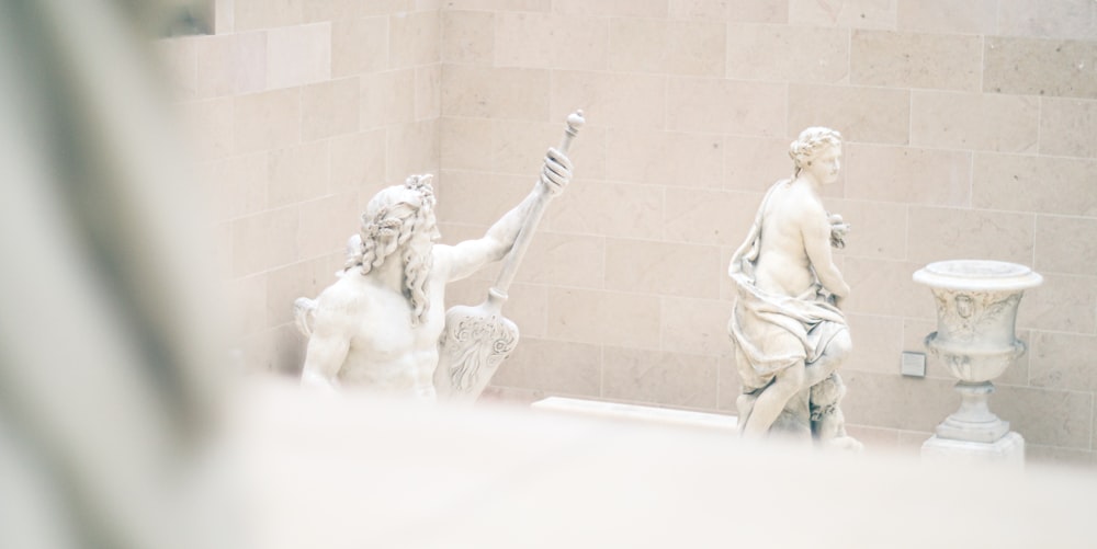 a statue of a man holding a flag next to a statue of a woman