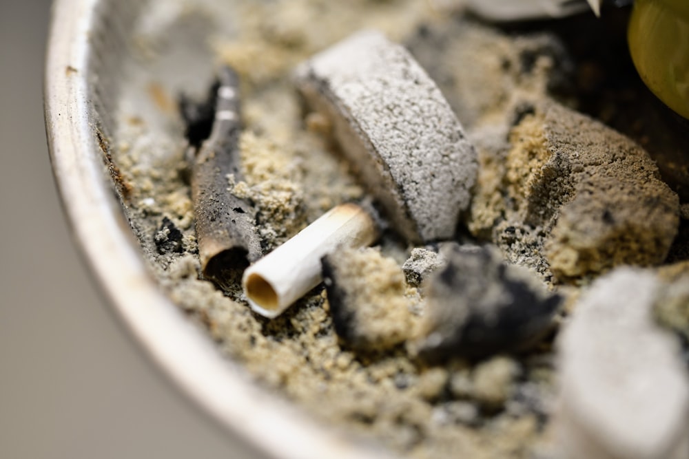 a close up of a bowl of food with a cigarette in it